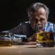 Un homme regardant un verre d'alcool